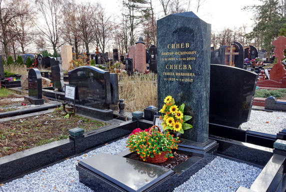 Вертикальная стела из чёрного камня и наполненный землёй цветник